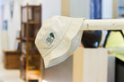 An off-white bucket hat with a green embroidered wording "Keep Chasen Your Dream" and a whisk.