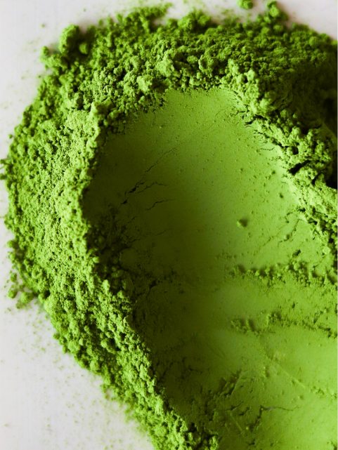 A scoop drawn through loose matcha powder